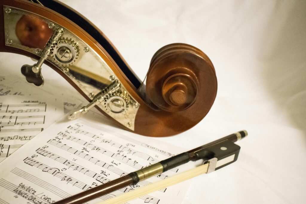 musical notes with the frog of a bow and the scroll of a string instrument lying on top of the musical notes
