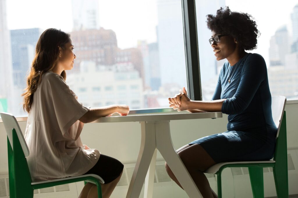 Professionals maintaining eye contact across a table while having a discussion as part of 3 body language tips for career success.