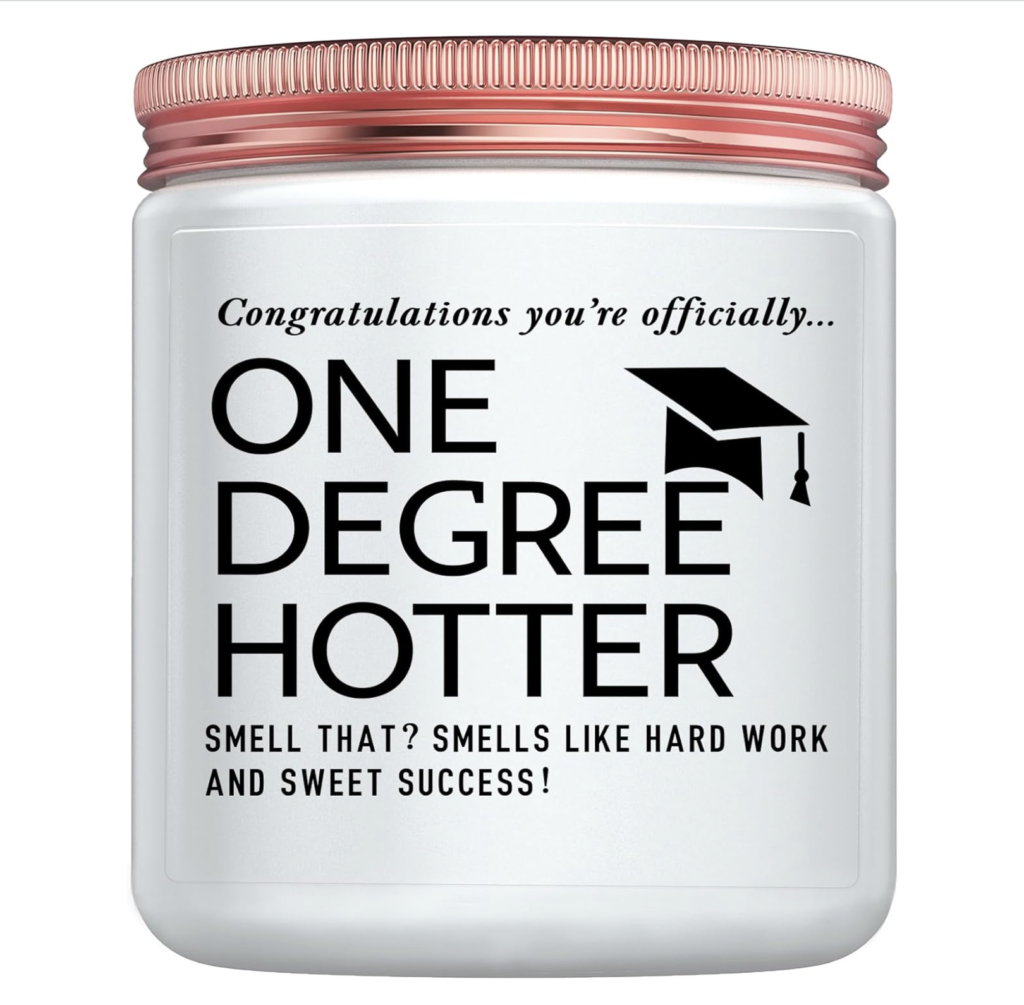 White candle jar with a rose gold lid featuring the quote “Congratulations you’re officially… One Degree Hotter. Smell that? Smells like hard work and sweet success!” and a small graduation cap graphic.