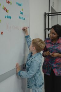 inexpensive 12 days of christmas gift ideas - a teacher helps a student at the whiteboard