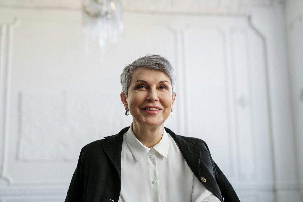 an image of a well-kept mature woman with short gray hair, white blouse, and blazer.