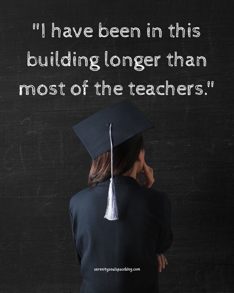 Graduate in black cap and gown facing away against a dark textured background, with the quote “I have been in this building longer than most of the teachers.” displayed above and serenitysoulspaceblog.com at the bottom.
