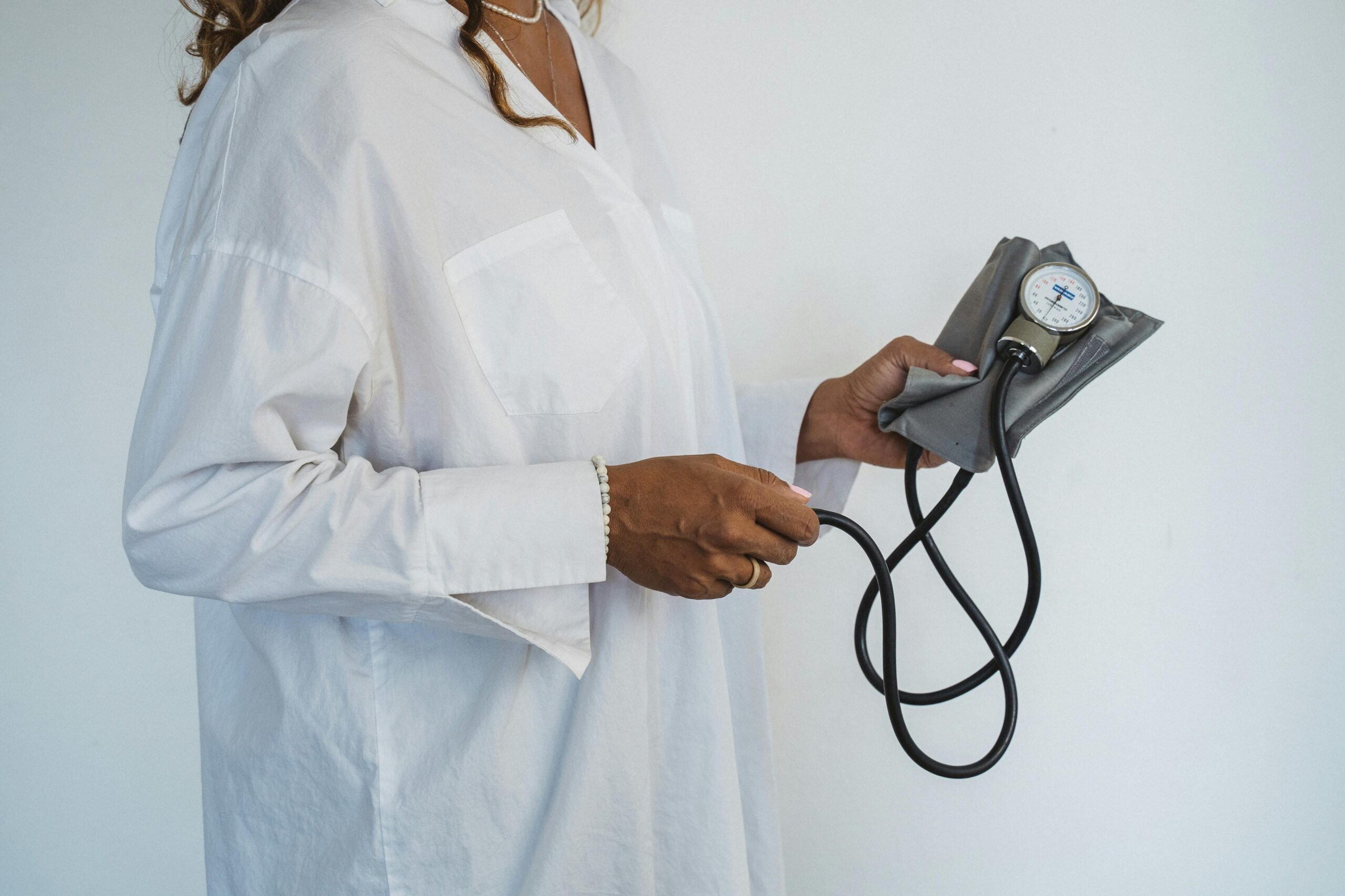 medical personnel holds a blood pressure cuff in her hands