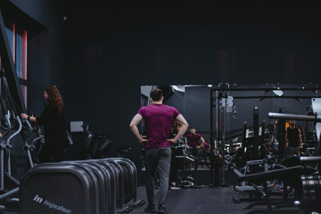 a man is in the gym and is walking away from the treadmill that he just got off