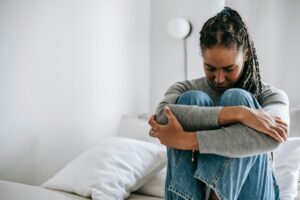 30 day blog challenge - a woman living with regret. Knees to chest, arms hugging her knees to her chest