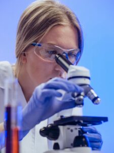 best stem cell serum for face - a female scientist looking at slides through a microscope