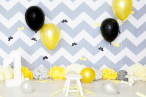 how to be your own cheerleader - an empty stool with pompoms and balloons in the chevron gray & white background