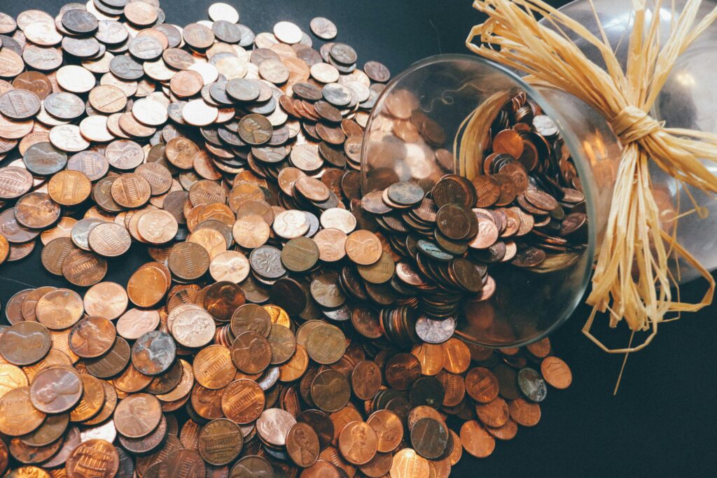 welcome back to school - hundreds of coins on a table from a jar toppled over