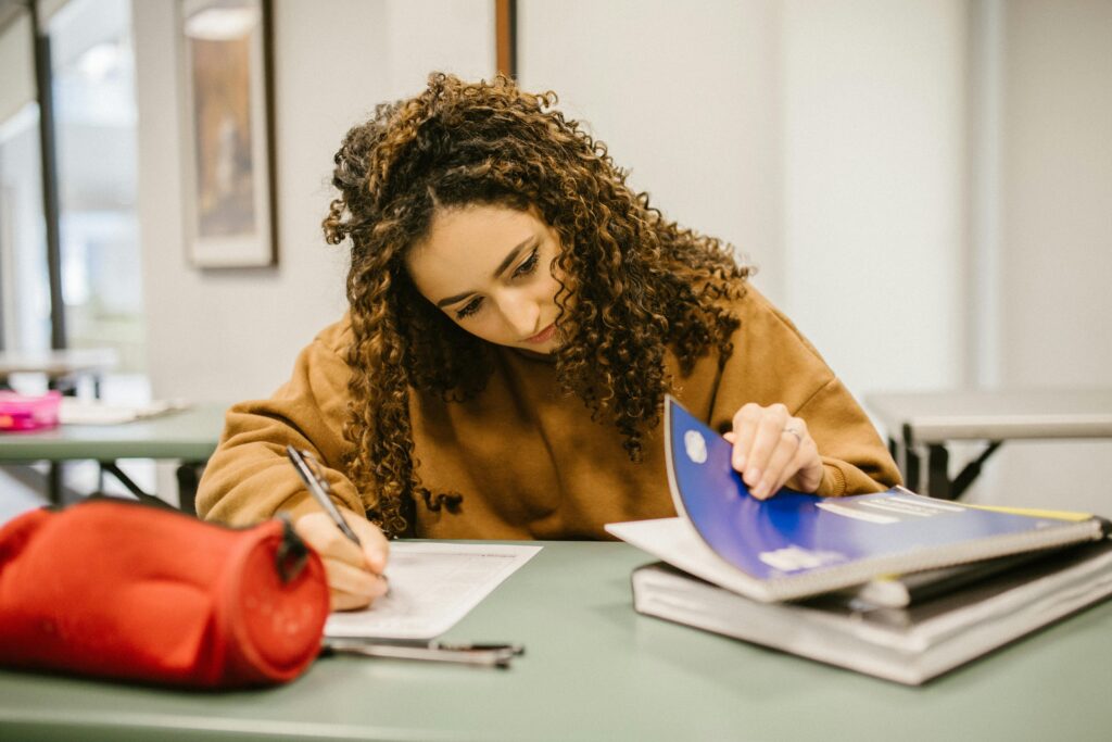 study tips for students with adhd - a woman surrounded by books and notebooks studying