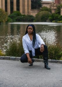 non-negotiables for setting boundaries - a woman poses low to the grown with a white long sleeve top and black leather pants exhibiting "that girl" energy