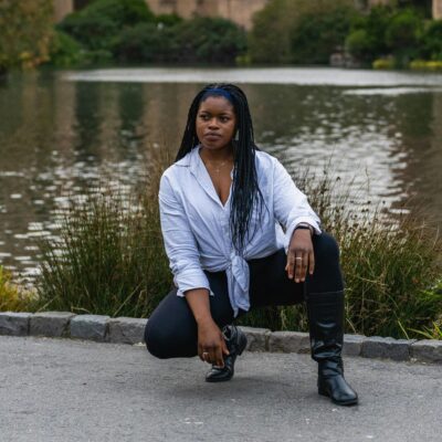 non-negotiables for setting boundaries - a woman poses low to the grown with a white long sleeve top and black leather pants exhibiting "that girl" energy