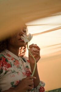 30 day glow up challenge to becoming her - a woman smells a rose in solitude