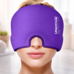 Woman wearing a purple ONLYCARE migraine relief cap in a spa-inspired setting with soft lighting and neutral background. The cap covers her eyes and ears only exposing her nose and mouth.