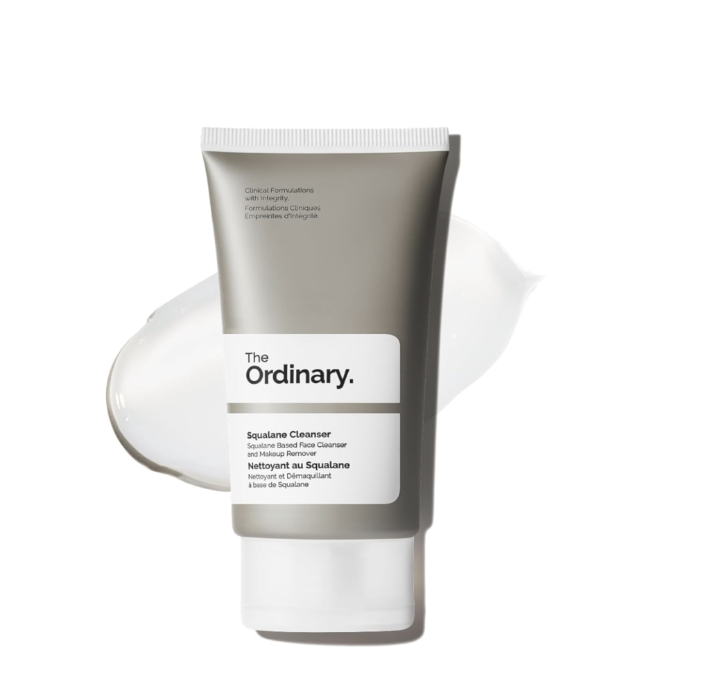 Silver tube of The Ordinary Squalane Cleanser standing on a white background with a translucent smear of cleanser behind it, showcasing the product used for gentle face cleansing and makeup removal.