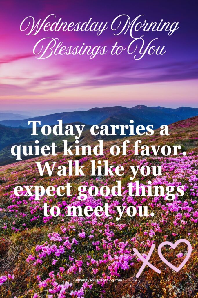 Pinterest-style graphic with a purple and pink sunrise over mountain hills covered in bright pink flowers. Text reads “Wednesday Morning Blessings to You” and “Today carries a quiet kind of favor. Walk like you expect good things to meet you.” A small heart and website name appear at the bottom.