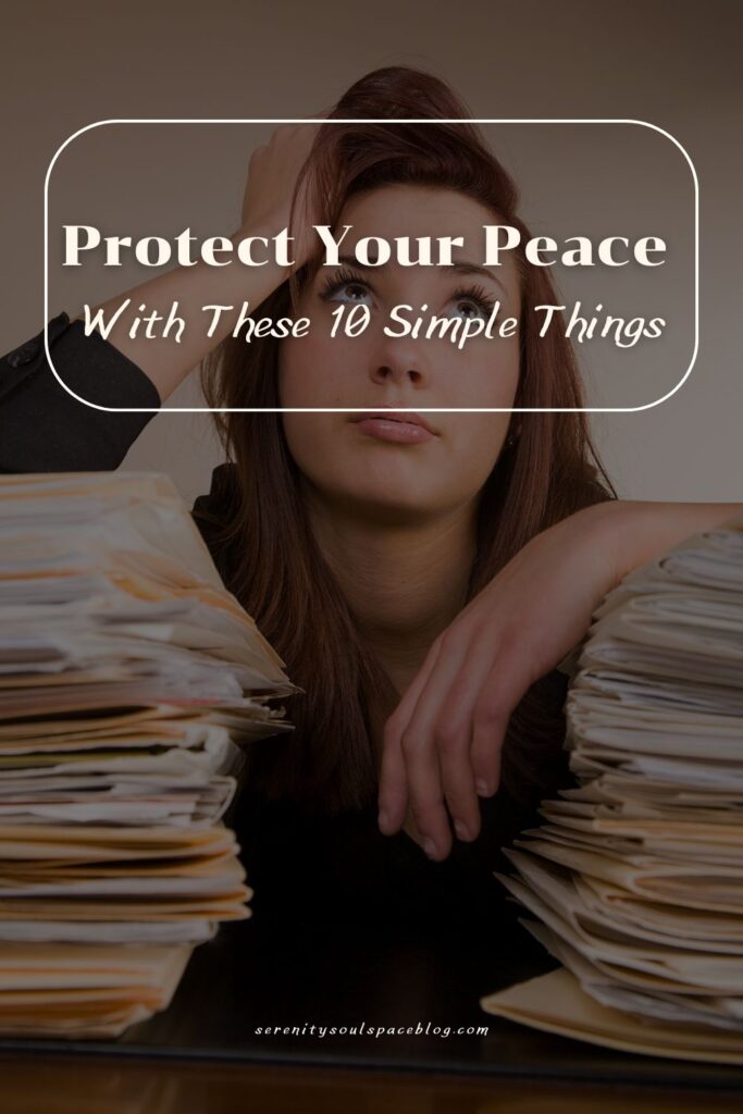 Pinterest pin featuring a stressed woman sitting between two large stacks of paperwork with her hand resting on her head. A white outlined text box overlays the image with the words “Protect Your Peace With These 10 Simple Things” in large white fonts. The image conveys overwhelm, stress, burnout, and the importance of protecting mental and emotional well-being.